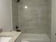 Modern bathroom featuring sleek tiles, granite vanity, and a bathtub-shower combination at 13024 Ne 6 Pl, Silver Springs, FL 34488
