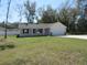 Single-story home with a well-maintained lawn, attached two-car garage, and covered front porch at 13024 Ne 6 Pl, Silver Springs, FL 34488