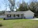 Charming single-story home boasts a well-manicured lawn, attached two-car garage, and a welcoming front porch at 13024 Ne 6 Pl, Silver Springs, FL 34488