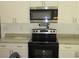 Close-up showcasing the modern stainless steel microwave and range at 13024 Ne 6 Pl, Silver Springs, FL 34488