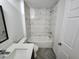 Bright bathroom featuring a tub and shower with white marble-look tile, with modern fixtures at 3733 Se 137Th Street, Summerfield, FL 34491