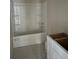 Simple bathroom with a bathtub and shower combination and white vanity at 4131 Se 130Th Pl, Belleview, FL 34420