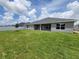 Beautiful backyard with green grass, gray house and white fence under a blue sky and clouds at 8309 Sw 58Th Ave, Ocala, FL 34476