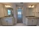 Hallway bathroom boasts double vanities with granite countertops and large mirrors at 8309 Sw 58Th Ave, Ocala, FL 34476