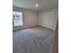 This bedroom has neutral walls, gray carpet, a window with a white frame, and a closet at 8309 Sw 58Th Ave, Ocala, FL 34476