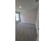This bedroom has neutral walls, gray carpet, and a window with a white frame at 8309 Sw 58Th Ave, Ocala, FL 34476