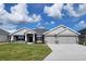 Beautiful single Gathering home featuring a 3-car garage and well-maintained lawn with decorative stone accents at 8309 Sw 58Th Ave, Ocala, FL 34476