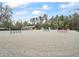 Wide shot of Equestrian Arena with riding jumps and training course, framed by picturesque woodland at 965 Nw 73Rd Ter, Ocala, FL 34482