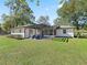 Backyard of home featuring pergola, screened in patio, and a lush green lawn at 965 Nw 73Rd Ter, Ocala, FL 34482
