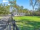 Scenic exterior view of horse barn, featuring lush pastures, black fencing, and a long driveway at 965 Nw 73Rd Ter, Ocala, FL 34482