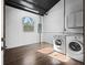 Bright laundry room features a washer and dryer, window, and modern wood-look tile flooring at 965 Nw 73Rd Ter, Ocala, FL 34482