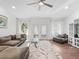 Bright living room with wood floors, neutral rug, modern ceiling fan, and patio access at 965 Nw 73Rd Ter, Ocala, FL 34482