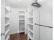 Walk-in closet with wood-look flooring, custom shelving, and ample storage space at 965 Nw 73Rd Ter, Ocala, FL 34482