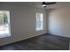 Bright bedroom with two windows, ceiling fan, and grey vinyl flooring at 13441 Sw 113Th Pl, Dunnellon, FL 34432