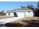 One-story house with gray siding, white garage door, and a stone accent at 13441 Sw 113Th Pl, Dunnellon, FL 34432