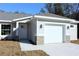 One-story house with gray siding, white garage door, and a stone accent at 13441 Sw 113Th Pl, Dunnellon, FL 34432