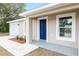 A single-story home featuring a blue front door, white garage door, well-manicured lawn, and neutral color scheme at 1877 Sw 150 Ct, Ocala, FL 34481