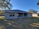 Rear view of a home with a backyard and covered porch, with lawn at 7695 Sw 103Rd Loop, Ocala, FL 34476