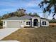 Gray one-story house with gray roof, two car garage, and landscaping at 7695 Sw 103Rd Loop, Ocala, FL 34476