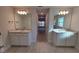 Bright bathroom featuring double sinks, granite countertops, and wood-look tile at 7703 Sw 103Rd Loop, Ocala, FL 34476