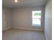 Bedroom features a large window and neutral carpeting at 7703 Sw 103Rd Loop, Ocala, FL 34476