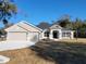 Charming single-story home with a gray exterior, well-manicured lawn, and a two-car garage at 7703 Sw 103Rd Loop, Ocala, FL 34476