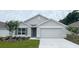 Charming single-story home featuring a gray color scheme, two-car garage, and a well-manicured lawn at 11152 Se 68Th Ct, Belleview, FL 34420