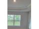 Bright living room featuring tray ceilings and a large window with serene backyard views at 11503 Sw 65Th Avenue Rd, Ocala, FL 34476