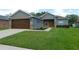 Inviting front view of a one-story home with a well-kept lawn and two car garage at 4085 Sw 49Th Ave, Ocala, FL 34474