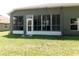 Back view of the house featuring a sunroom with wall-to-wall windows and a door at 4085 Sw 49Th Ave, Ocala, FL 34474