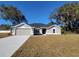 Charming single-story home with a well-manicured lawn and a freshly painted gray exterior at 7605 Sw 103Rd Loop, Ocala, FL 34476