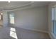 Carpeted main bedroom featuring a ceiling fan, base molding, and a view of the backyard at 7605 Sw 103Rd Loop, Ocala, FL 34476