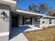 Inviting entryway with a stylish front door, classic black shutters, and manicured landscaping at 7613 Sw 103Rd Loop, Ocala, FL 34476