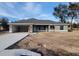 Newly constructed gray house with a two-car garage and a spacious front yard at 7613 Sw 103Rd Loop, Ocala, FL 34476