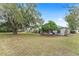 Home's backyard features a large oak tree and manicured lawn at 8718 Sw 83Rd Loop, Ocala, FL 34481