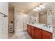 Main bathroom with double sinks, large shower, and tropical-themed wallpaper at 8718 Sw 83Rd Loop, Ocala, FL 34481