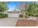 White house exterior with a paver driveway and neatly landscaped yard at 8718 Sw 83Rd Loop, Ocala, FL 34481