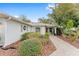 Single-story house with a red door and well-maintained landscaping at 8718 Sw 83Rd Loop, Ocala, FL 34481