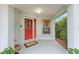 Inviting front porch with a red door and welcome mat at 8718 Sw 83Rd Loop, Ocala, FL 34481