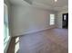 Spacious bedroom with large windows, plush carpeting, a tray ceiling and neutral colored walls at 9679 Sw 46Th Ct, Ocala, FL 34476