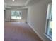 Bright bedroom with plush carpeting, natural light, and a modern tray ceiling design at 9679 Sw 46Th Ct, Ocala, FL 34476