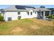 Rear view of house featuring solar panels, patio, and a spacious backyard at 5226 Nw 21St Loop, Ocala, FL 34482