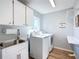 Laundry room with washer, dryer, sink, and ample cabinet space at 5226 Nw 21St Loop, Ocala, FL 34482