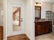 Hallway view of a bathroom featuring granite counters and dark wood cabinetry at 9901 Nw 6Th Ct, Ocala, FL 34475
