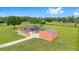 A beautiful country estate showcasing the home and barn in a lush green setting with a vast, open field at 9901 Nw 6Th Ct, Ocala, FL 34475