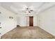 Spacious main bedroom with a decorative tray ceiling and sliding barn door to the en-suite bathroom at 9901 Nw 6Th Ct, Ocala, FL 34475