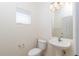 This half bathroom offers a pedestal sink, tiled flooring, and a window for natural light at 4950 Sw 45Th Cir, Ocala, FL 34474