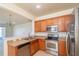 This kitchen features stainless steel appliances, wood cabinets, and a seamless transition to the adjacent living space at 4950 Sw 45Th Cir, Ocala, FL 34474