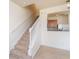 Carpeted staircase with white railing, offering a partial view into the well-equipped kitchen at 4950 Sw 45Th Cir, Ocala, FL 34474