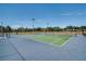 Well-maintained tennis courts with green surface, surrounded by fencing and lush greenery at 4950 Sw 45Th Cir, Ocala, FL 34474